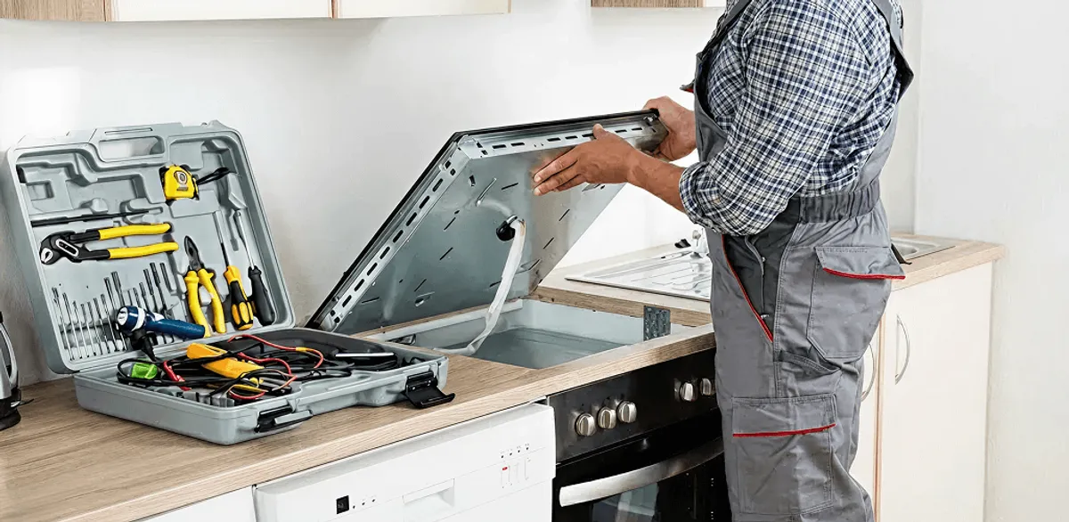 Handyman repairing a cooktop and checking wiring connections in Kansas City, KS